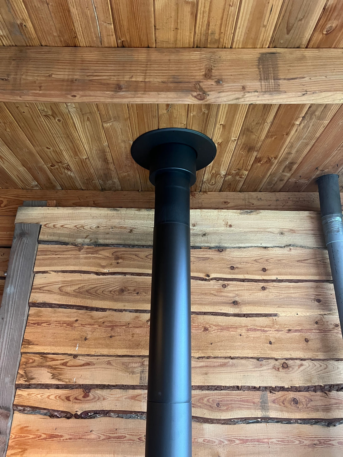 Verandakachel met dubbelwandig zwart rookkanaal door het houten dak in Nieuw-Vennep
