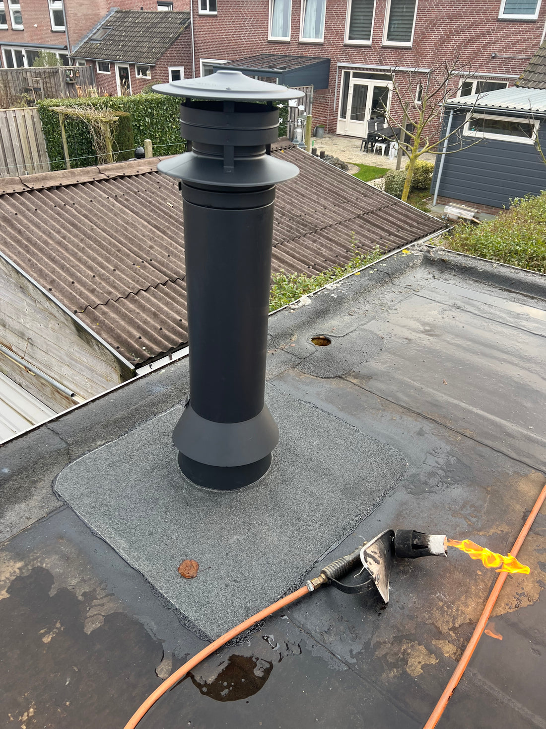 Rookkanaal van de verandakachel netjes door het dak, buitenzijde in Nieuw-Vennep