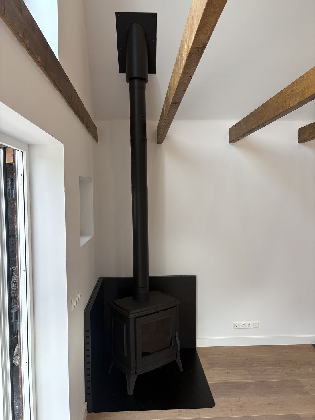 Invicta Sedan M houtkachel met zwarte warmtepanelen in de bijwoning in Wijdewormer