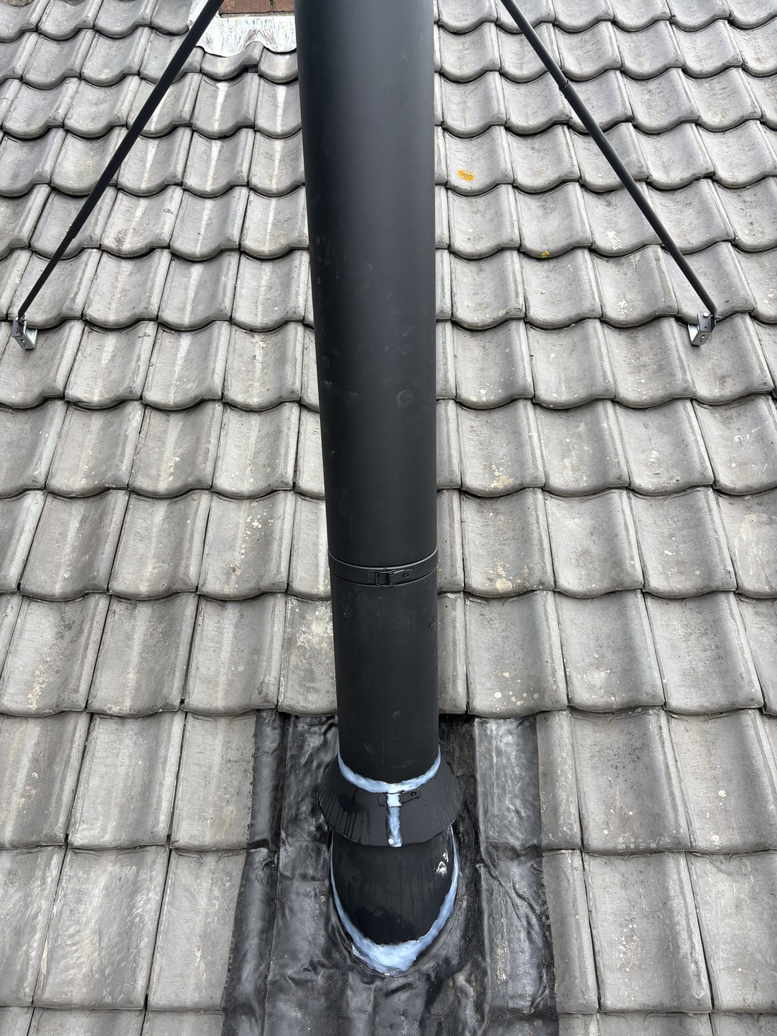 Loodvervangende dakplaat rond de dakdoorvoer van het rookkanaal, detail