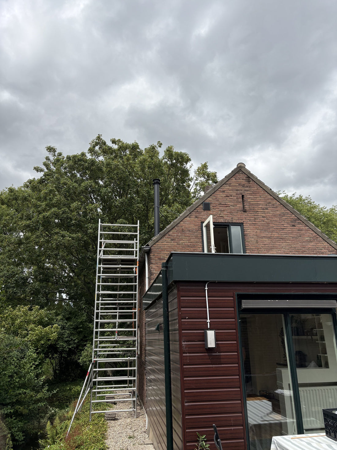 Woning in Aalsmeer met ladder tijdens de plaatsing van het rookkanaal