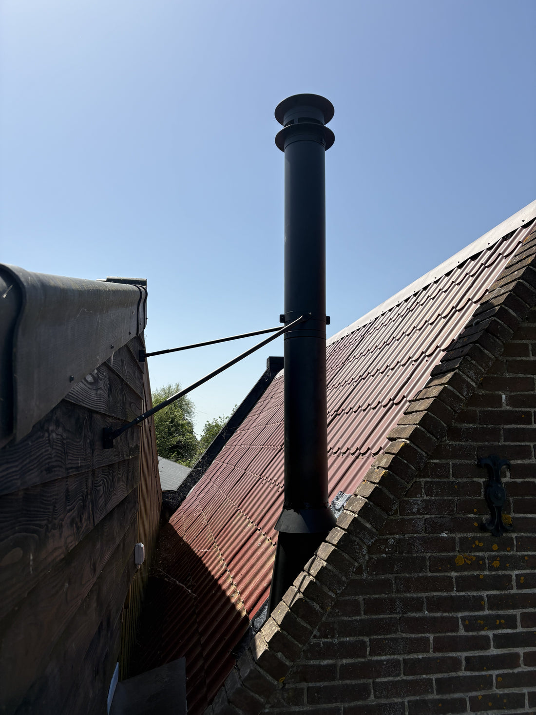 Dakdoorvoer van het rookkanaal op het dak van de bijwoning in Wijdewormer