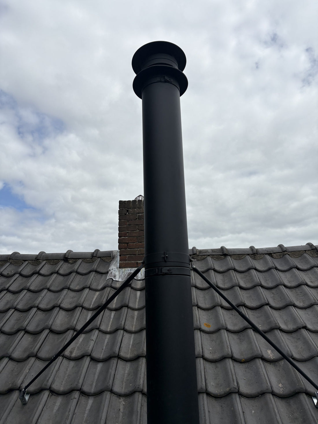Zwart dubbelwandig rookkanaal op het dak van de woning in Aalsmeer